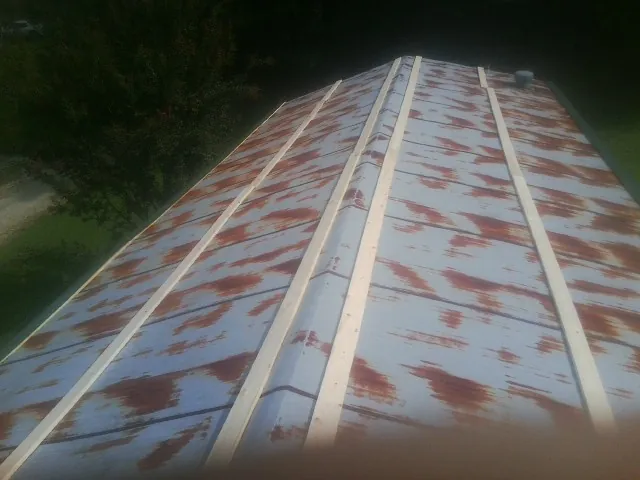 Rusted metal roof panels with new wood purlins before replacement — Storm Damage Roof Repair in Bradenville by Roofing Brothers