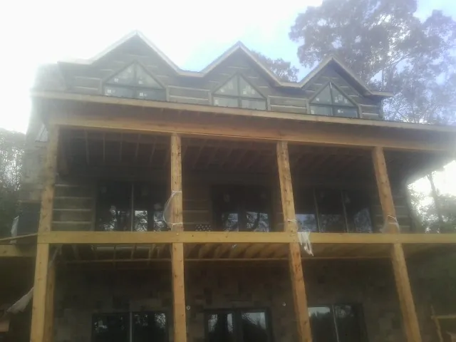Dormers and porch framing on a large log home under construction — Roof Coating work by our crew in Bradenville
