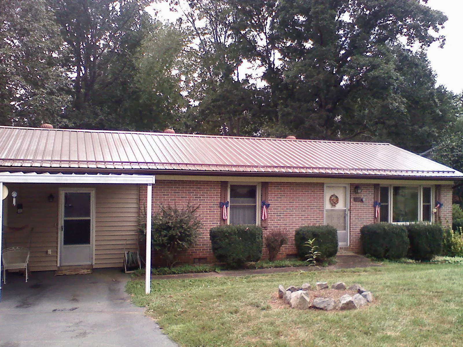 Bronze metal roof and carport on a brick ranch home — Roof Repair work by our crew in Bradenville